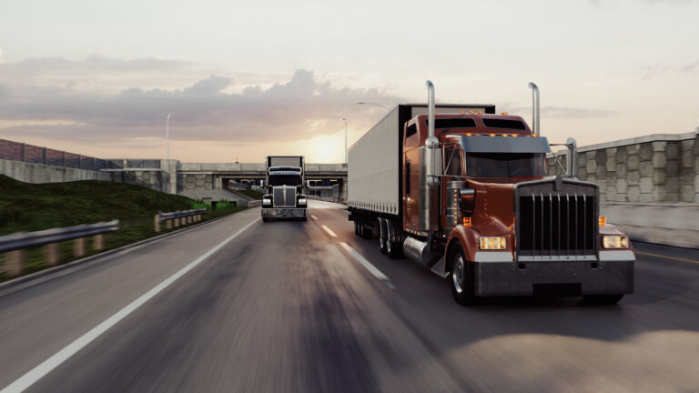 American style truck on freeway pulling load.