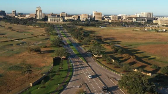 Aerial view of wide avenue with green medians and few cars