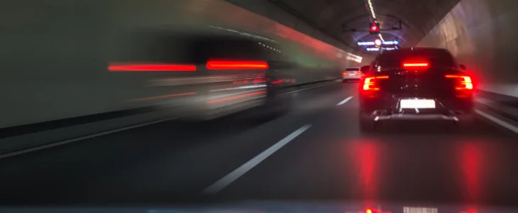 View from out of a car windshield with brake lights illuminated ahead