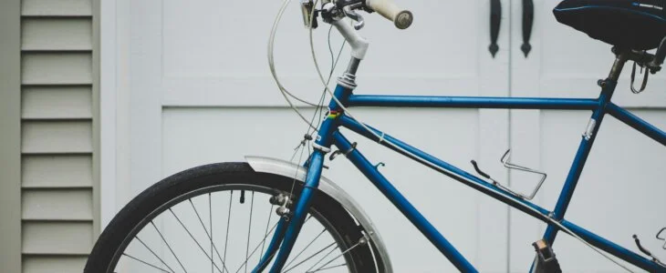 Blue road bike parked in front of a white garage door